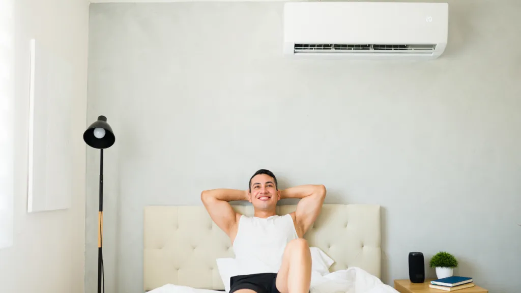 A man enjoying the climate in a room controlled by a ductless mini split ac unit
